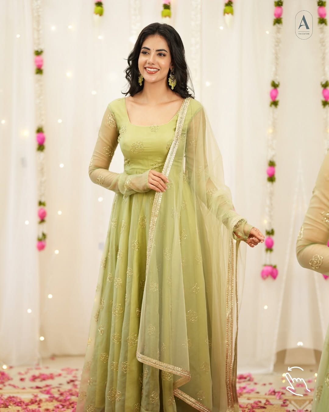 Woman in a light green traditional outfit with a sheer dupatta against a decorative background.