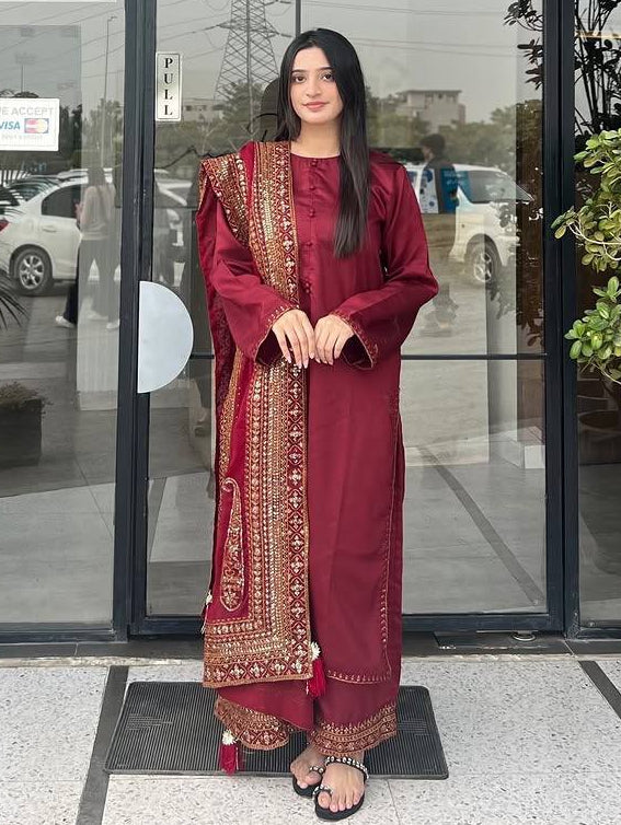 Woman in a red traditional outfit standing outside a building with 'Casa Rica' signage.