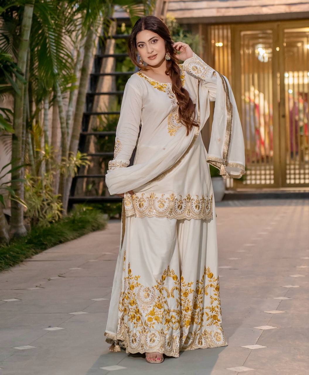 Radiant Heritage: Two Women Embodying Cultural Splendor in a Majestic Indian Courtyard