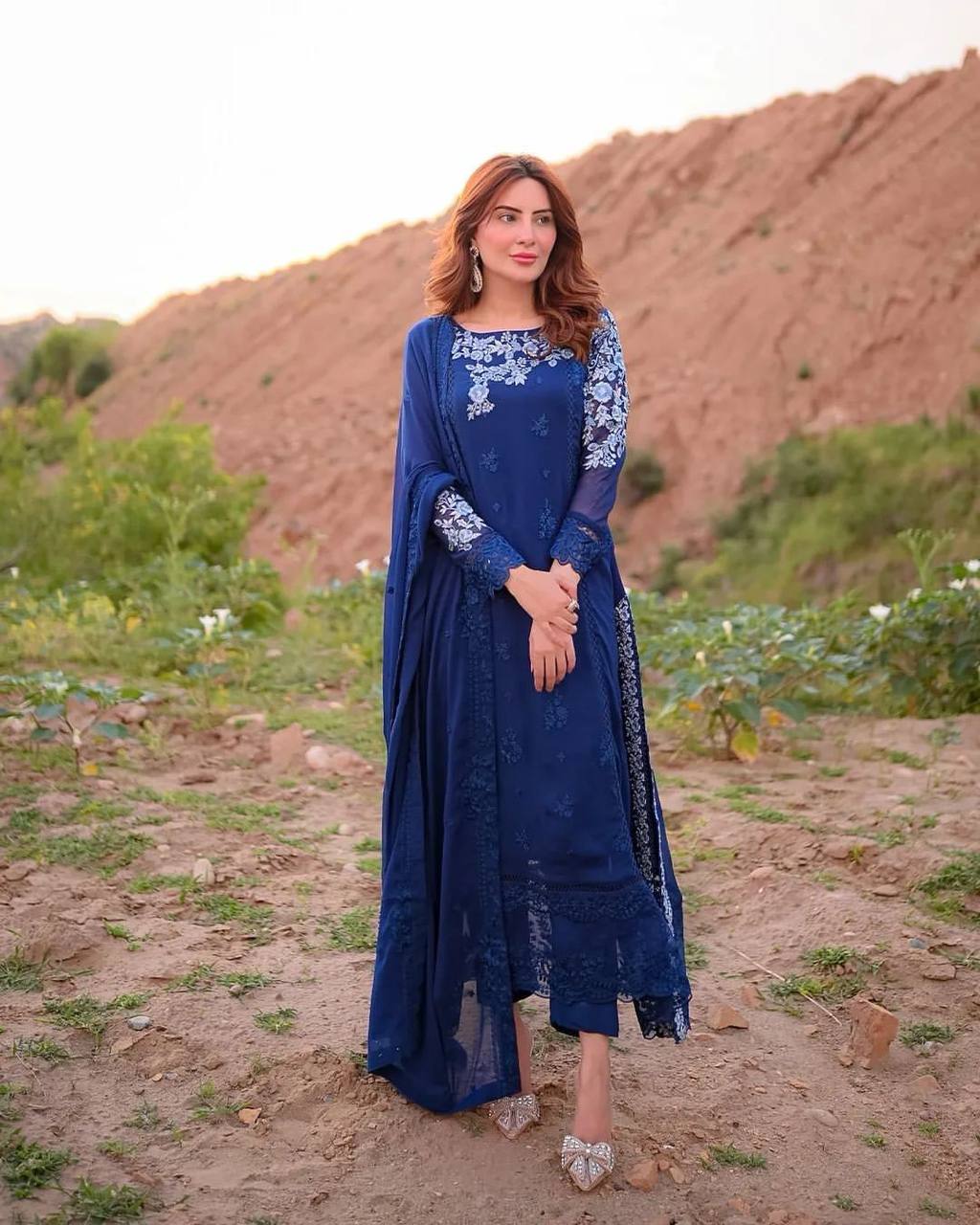 "Elegant Woman in Blue Embroidered Dress Amidst Natural Scenery"