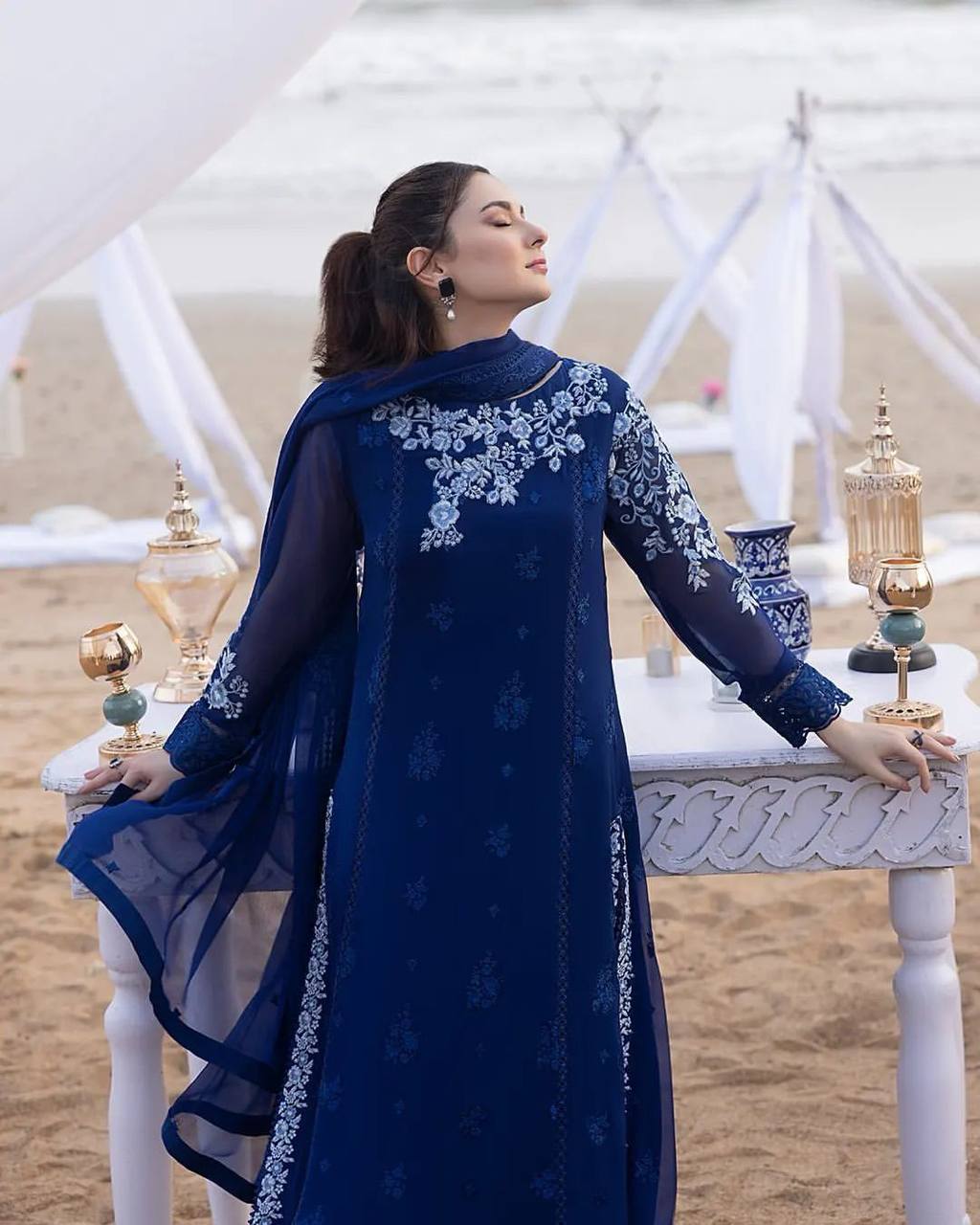 "Elegant Woman in Blue Embroidered Dress Amidst Natural Scenery"