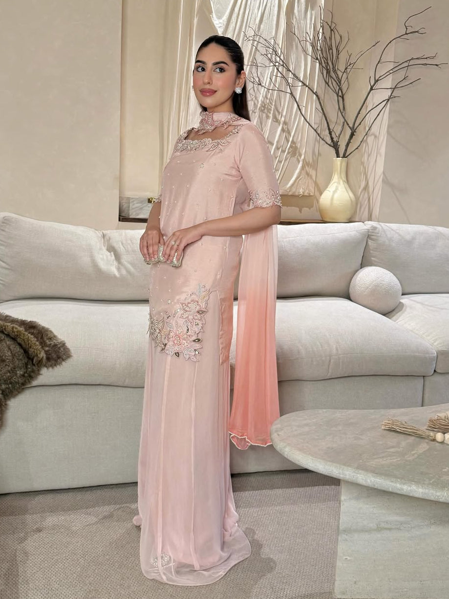 Woman in a pink dress standing in a modern living room.